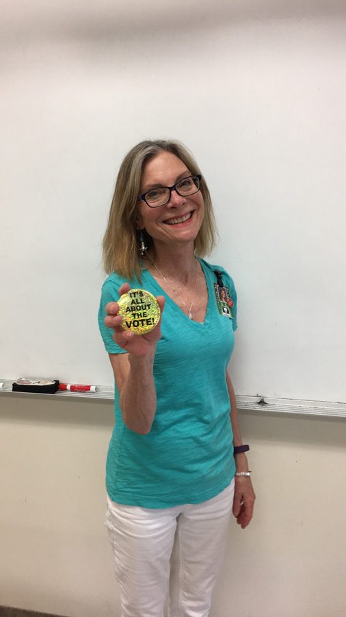 Sara+Buley+holds+up+her+%22It%27s+all+about+the+vote%22+pin.++Buley+believes+strongly+in+voting+in+each+election%2C+and+she+urges+her+students+to+do+this+important+civic+duty.